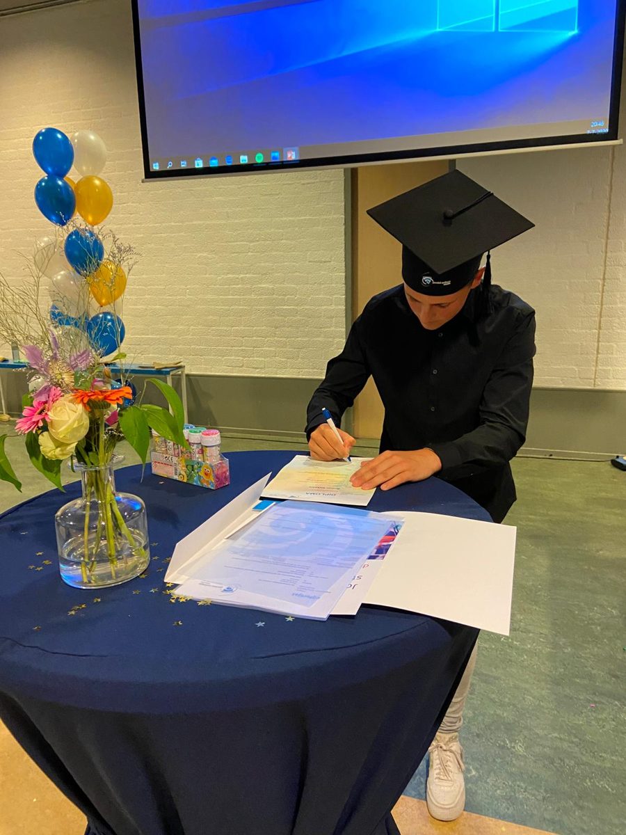 Roman tekent zijn diploma tijdens de diploma-uitreiking